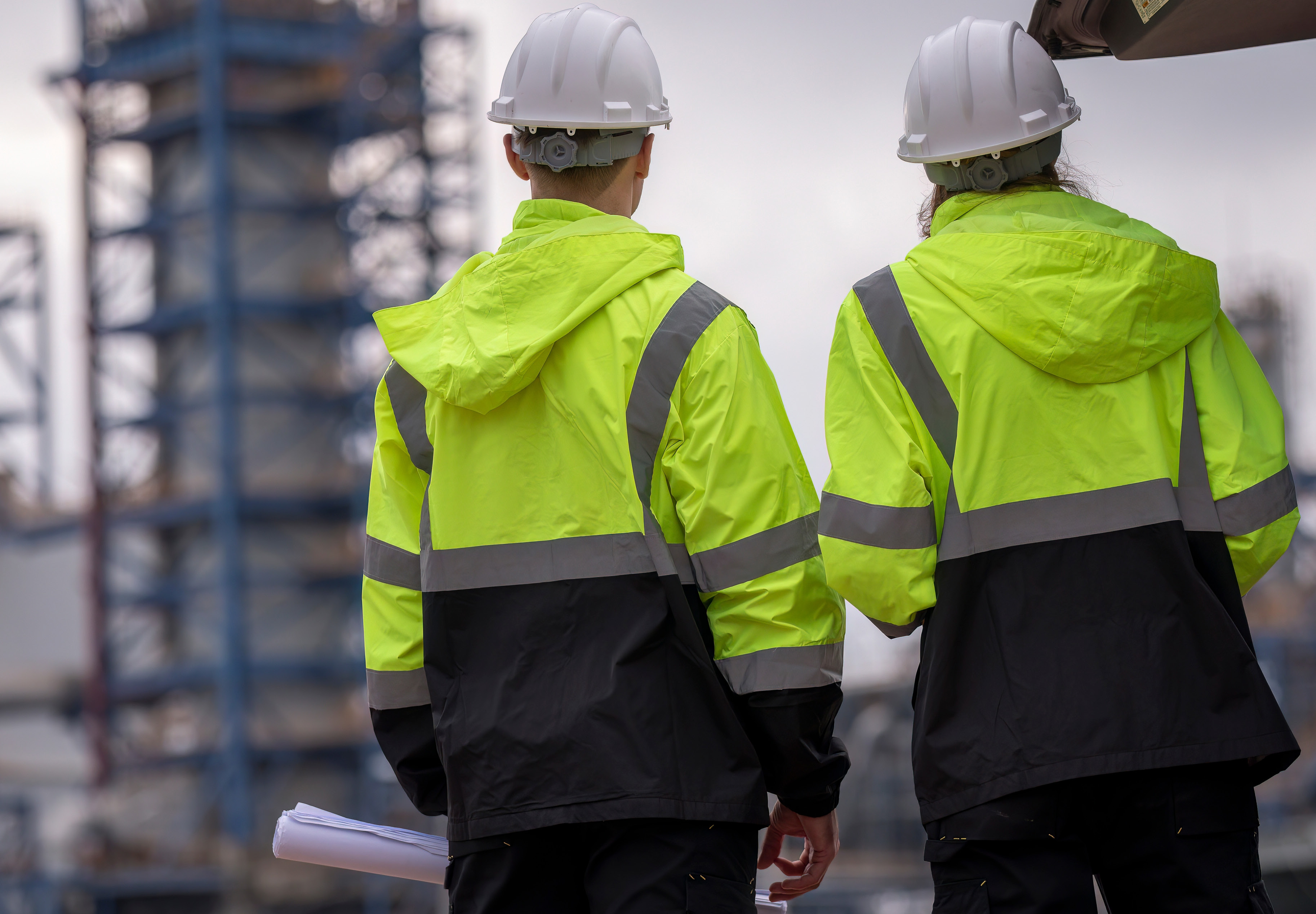 Health and safety workers in hi-vis jackets on site