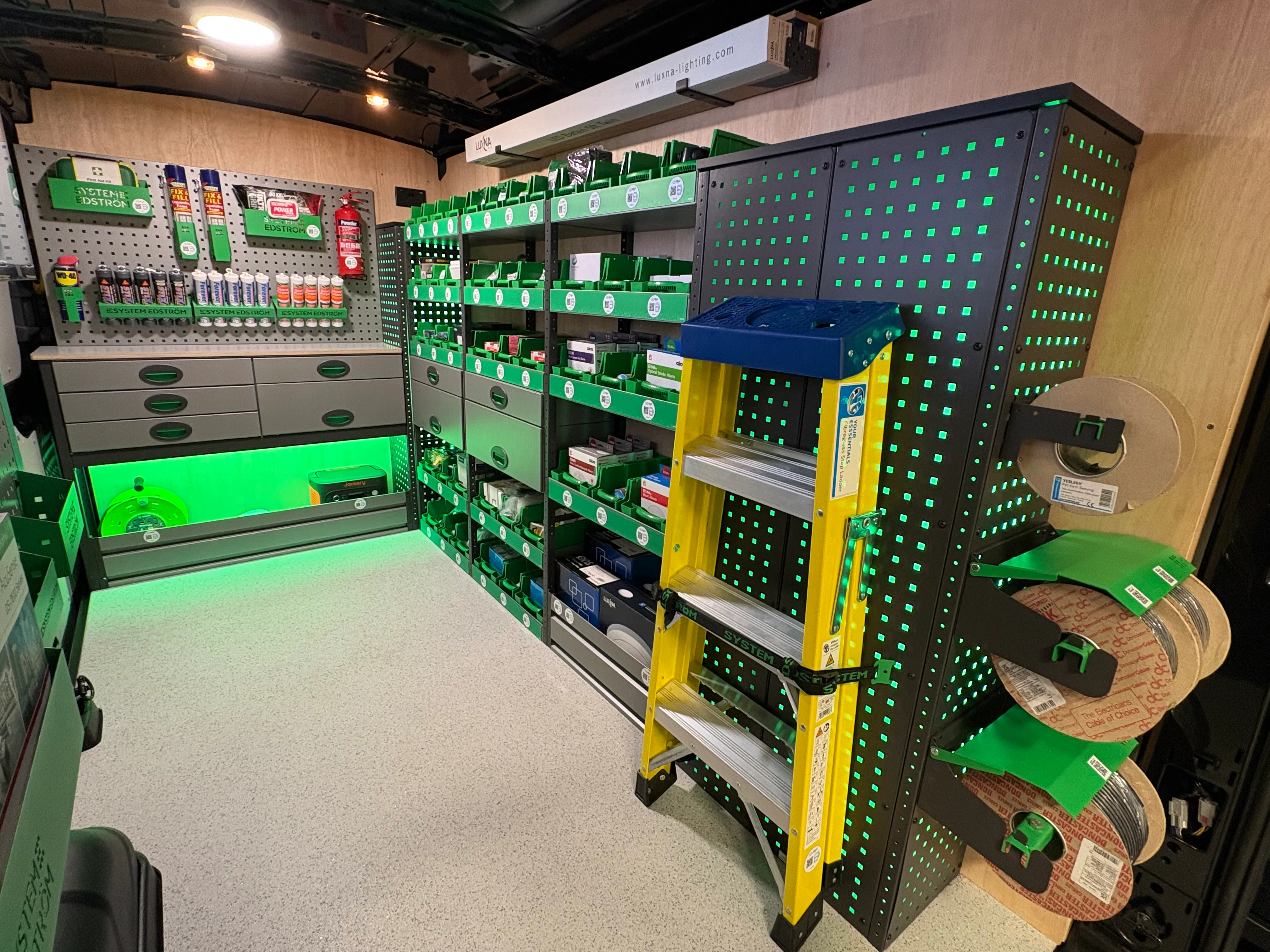 Van interior fitted with organised, illuminated stock shelving